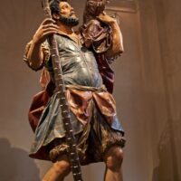 Una statua di legno con il bambino. Lo tiene con una mano in evidenza.