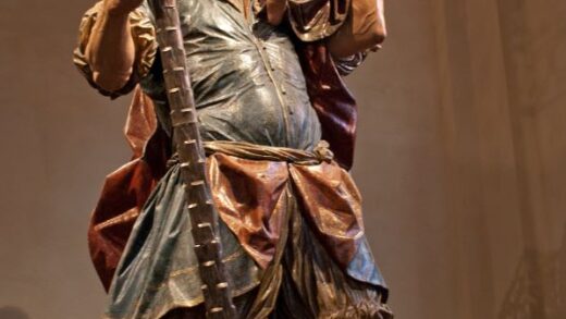 Una statua di legno con il bambino. Lo tiene con una mano in evidenza.